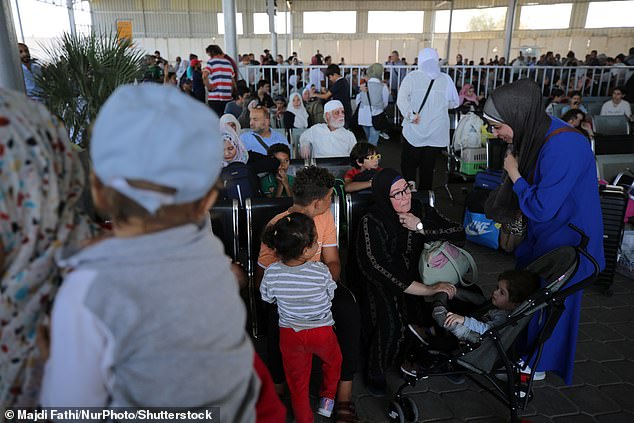 People with foreign passports wait at the Rafah border between Gaza and Egypt after it opened this week and following a negotiated deal to allow foreigners, including Americans, to leave the Palestinian enclave amid Israeli counterattacks