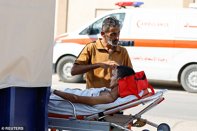 A medical worker attends to a Palestinian who will receive treatment in an Egyptian hospital