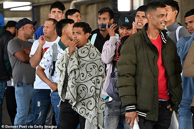 Venezuelan migrants wait in line to receive paperwork to be admitted to shelters at a migrant processing center in Denver, Colorado.  The city says it spends Denver $2 million a week sheltering migrants and needs federal help to cope