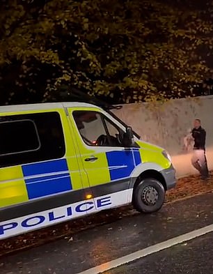 The lone officer appears to ignore questions from concerned passers-by