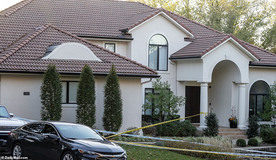 A security guard sat in his sedan parked in the driveway, tape on his side mirror stretching across the sidewalk and around the trees lining the property.