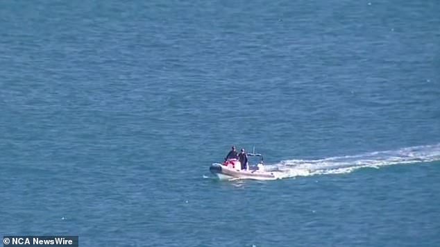 During the search for the missing surfer, two men are seen on a boat