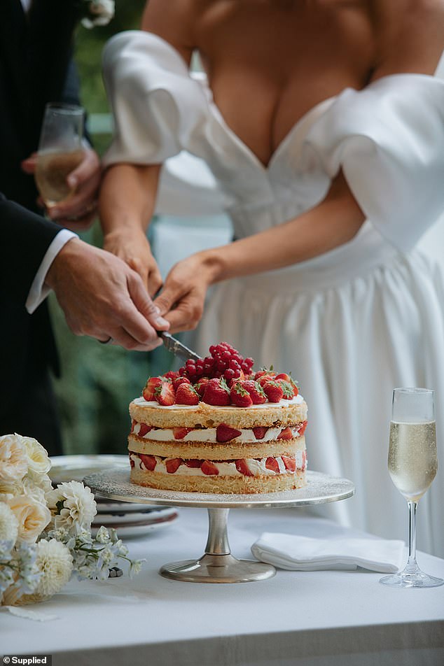 The couple is seen cutting their strawberry sponge cake