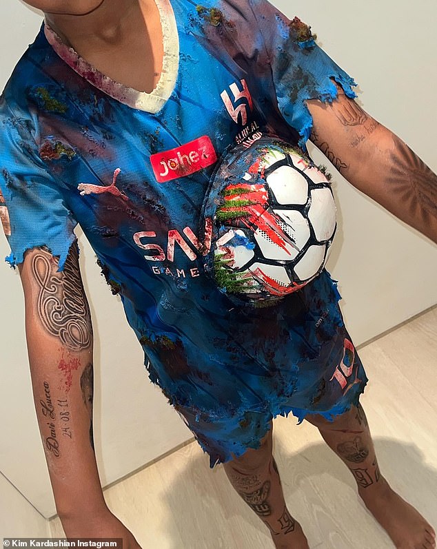 Details: Fake tattoos could be seen on his arms and legs as he struck a few poses for the camera with a football sticking out of the shirt