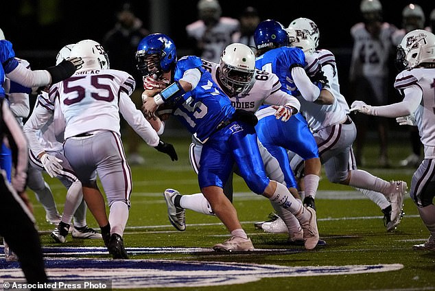 Football players from Lewiston High School and Edward Little High School compete during a high school football game, Wednesday, Nov. 1, 2023, in Lewiston, Maine.  Locals are seeking a return to normality after a mass shooting on October 25.  (AP Photo/Matt York)