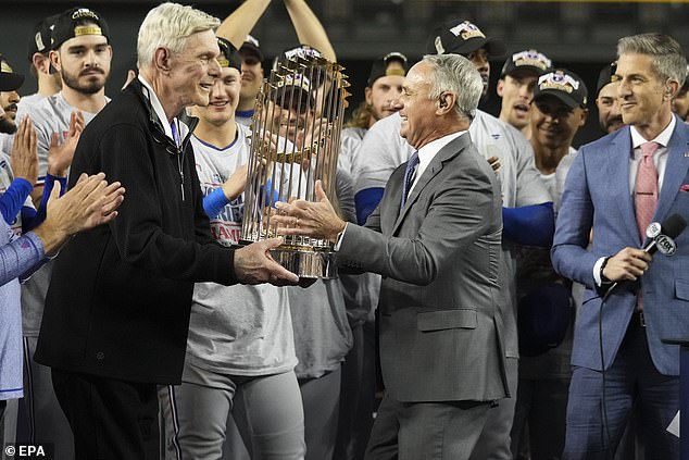 Rangers owner Ray Davis receives the Commissioners trophy from Manfred during the proceedings