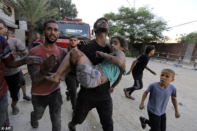 Palestinians carry an injured girl after being rescued Wednesday from the rubble of buildings destroyed by Israeli airstrikes in the Jabaliya refugee camp