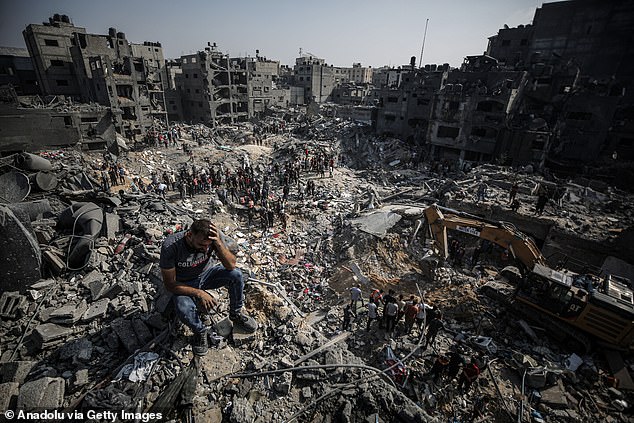 A man sits on rubble after an Israeli military airstrike in the Jabalya refugee camp in Gaza City on Wednesday