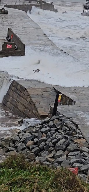 A video shared on social media captured the moment a woman branded an 'idiot' behind the camera was caught off guard by a treacherous wave on Tuesday.