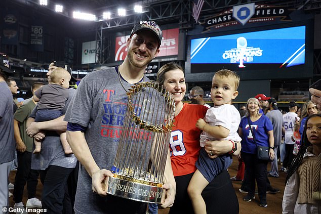 Mitch Garver (left) holds the Commissioner's Trophy as he celebrates with his family