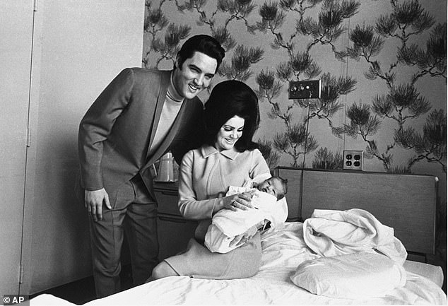 Lisa Marie Presley poses for her first photo, on the lap of her mother, Priscilla, on February 5, 1968, with her father, Elvis Presley