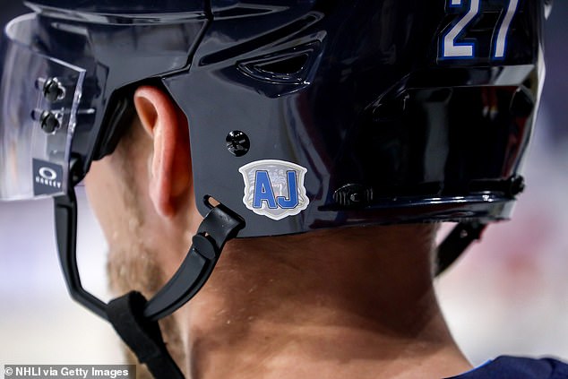 A detailed view of the emblem honoring Adam Johnson can be seen on Nikolaj Ehlers' helmet