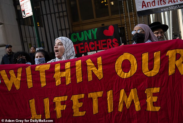 Protesters hold up a banned lecture 'Within our lives' outside the court on Thursday