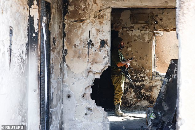 A soldier looks on inside a destroyed house riddled with bullets after the deadly attack by Hamas gunmen from the Gaza Strip on October 7 in kibbutz Kfar Aza, southern Israel on November 2