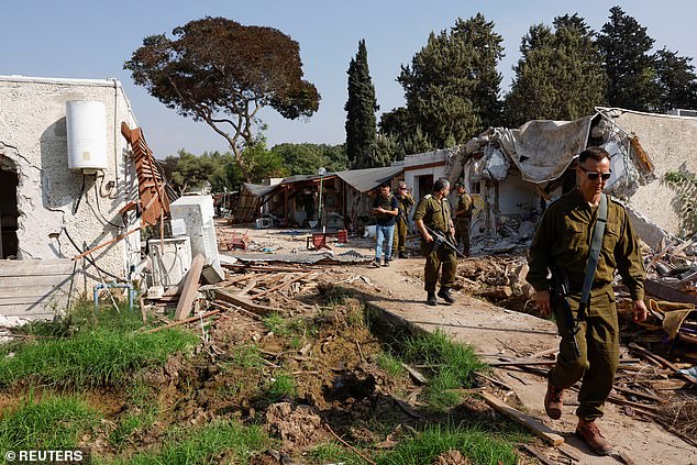 Soldiers walk near destroyed houses, after the deadly attack by Hamas gunmen from the Gaza Strip on October 7 in kibbutz Kfar Aza, southern Israel on November 2