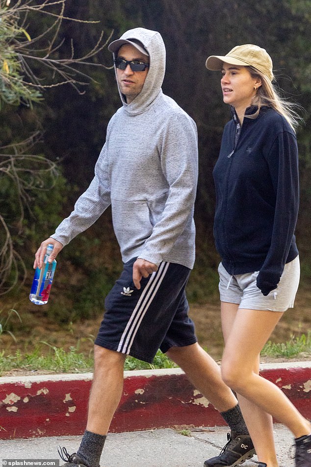 Casual customer: Robert kept his look simple in a gray pullover hoodie, black striped Adidas shorts and black On sneakers