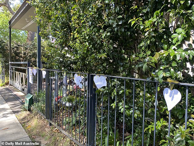 Pictured: Heart-shaped cards made by students from St Edward's School were seen lining the gate on Wednesday