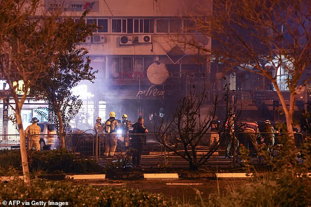 Israeli rescuers and firefighters check the rubble of burned vehicles after a rocket attack from southern Lebanon on the Israeli town of Kiryat Shmona in northern Israel on Thursday