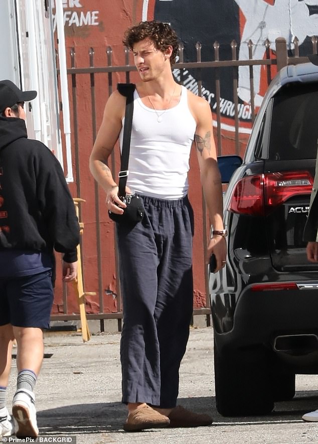 Casual: For his workout, the Canadian native showed off his ripped physique in a white tank top which he paired with dark gray sweatpants and brown clogs