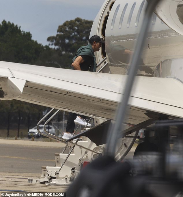 Patrick dressed casually in black pants and a matching colored T-shirt as he walked onto the plane