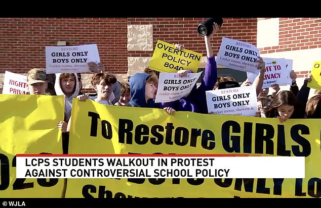 Students unfurled posters demanding the 2021 policy be rescinded