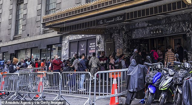 Officials in New York have warned that the migrant crisis is making resources scarce as they turn to some city landmarks and makeshift shelters to house them.  Pictured: Migrants line up for housing outside Manhattan's iconic Roosevelt Hotel