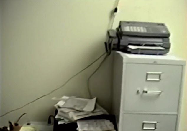 The short video shows an extension cord running from inside the home to a fax machine, due to the lack of sufficient electrical outlets in the room