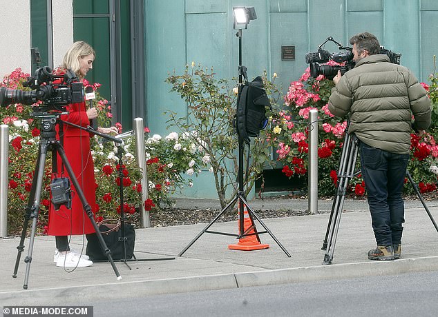 Television crews prepare for a live cross outside the court