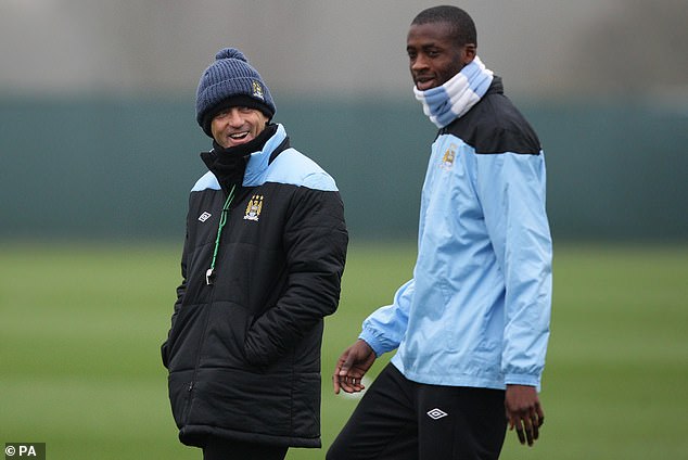 Toure (right) played three seasons under Mancini (left) when the Italian was Man City boss