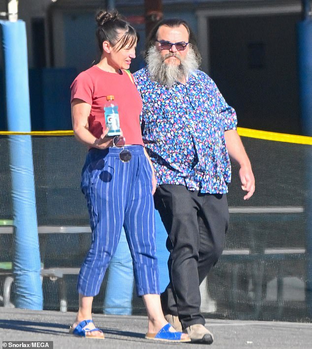 The actor wore a blue short-sleeved shirt covered in flowers in different colors, while Tanya wore a dark pink T-shirt and blue cut-off pants with bright blue sandals.