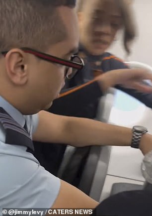 In the clip, cabin crew are seen surrounding the bag as the footage is shot over their shoulders