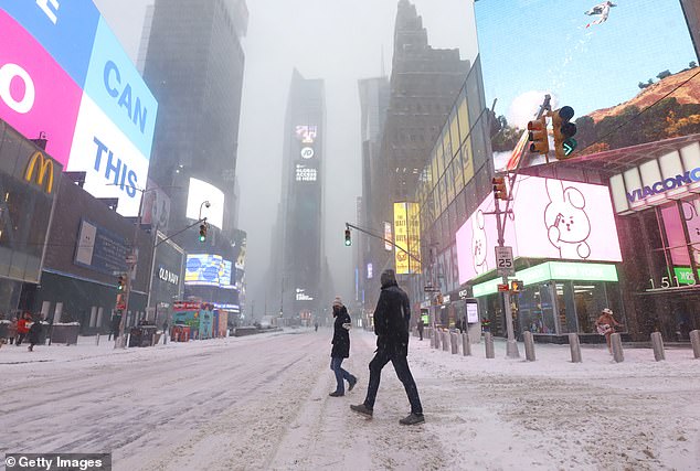 According to the National Oceanic and Atmospheric Administration, there was snow in 17.9 percent of the contiguous United States as of Wednesday morning (Photo: People walking along 7th Avenue in Times Square during a snowstorm on January 29, 2022)