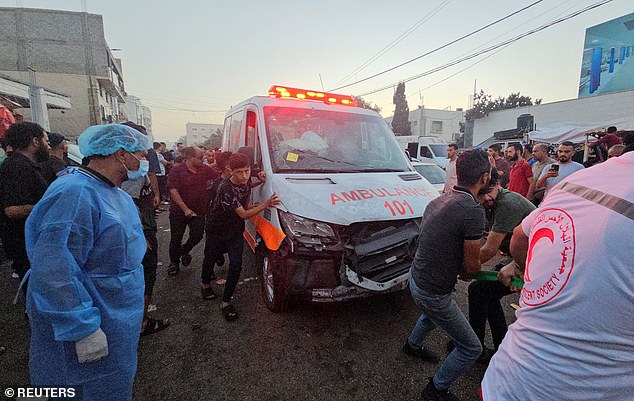 Palestinians pull an ambulance after a convoy of ambulances was hit, at the entrance to Shifa Hospital in Gaza City, November 3