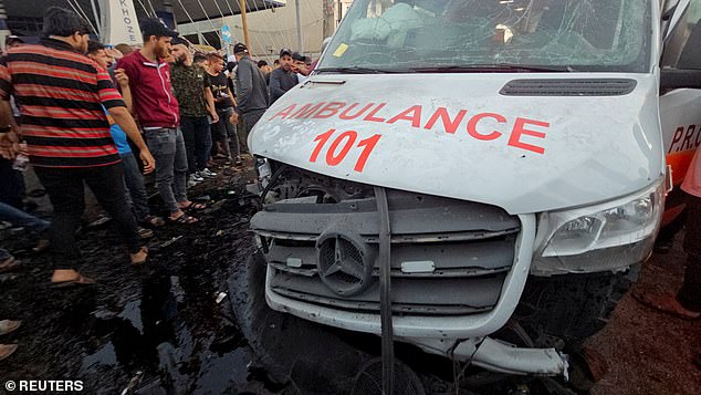 Palestinians check damage to an ambulance after a convoy of ambulances was hit, at the entrance to Shifa Hospital in Gaza City, November 3