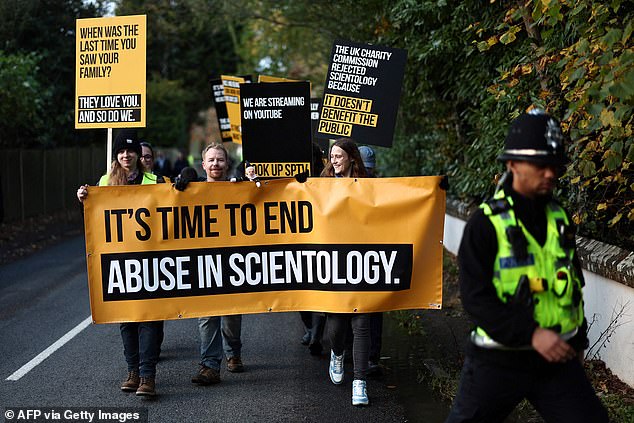 The group held banners and chanted slogans as they marched to Saint Hill Manor, the British headquarters of the Church of Scientology.