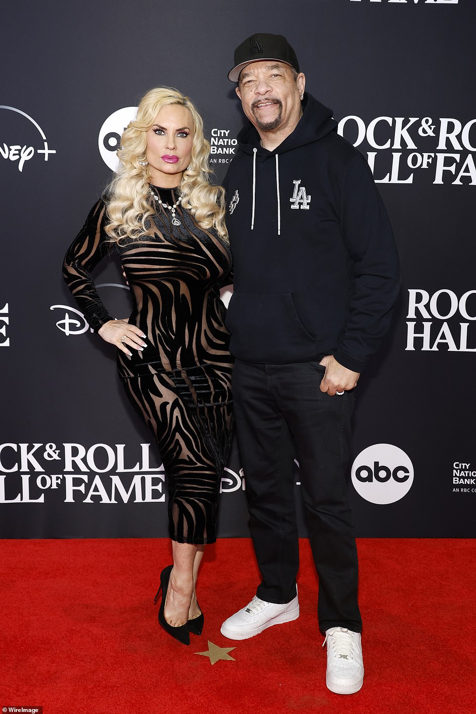 Strike a pose: Coco opted for a sheer black dress with lines all over and the space between them made of sheer fabric;  she added black pointy heels and a red lipstick necklace