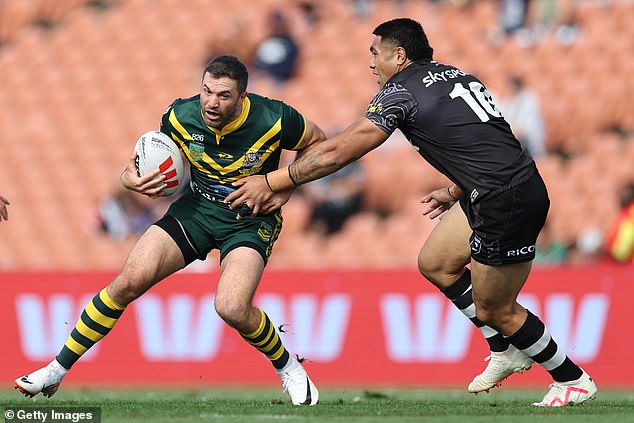 James Tedesco of Australia tries to get away from Moses Leota of New Zealand with empty seats behind him