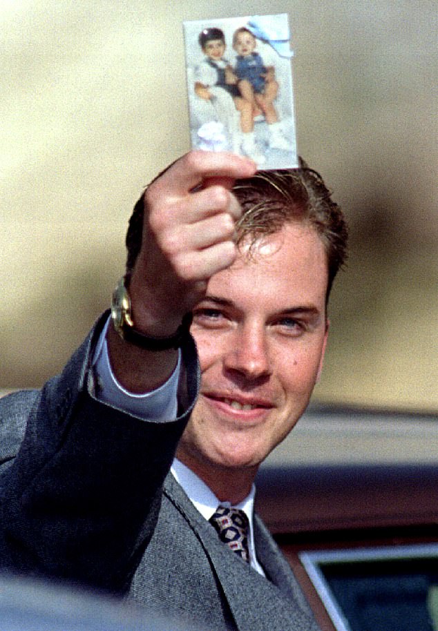 David Smith holds up a photo of his murdered sons Michael and Alex and smiles after his ex-wife (Susan) Smith is sentenced to life in prison for two murders