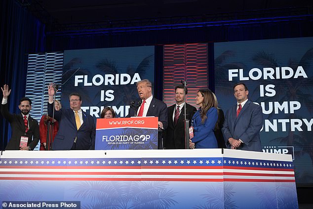 Former President Donald Trump, center, is on stage surrounded by supporters at the Republican Party of Florida's Freedom Summit in Kissimmee, Florida