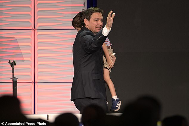 Republican presidential candidate Florida Governor Ron DeSantis waves to attendees while carrying his son Mason in his arms after speaking at the Republican Party of Florida's Freedom Summit