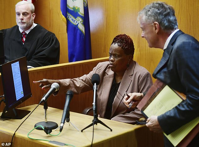 Bridgeport City Employee Wanda Geter-Pataky works with her attorney to know what questions to answer to avoid incriminating herself during her testimony in Bridgeport