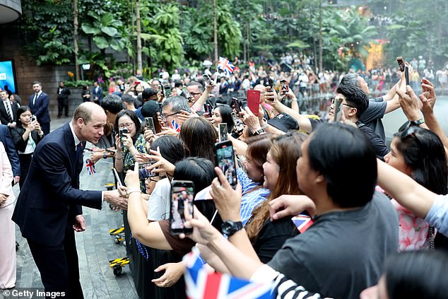 The Prince of Wales arrived at Changi Airport on Sunday to cheering crowds holding aloft signs, waving Union Jack flags and holding photos of his late mother, Princess Diana.