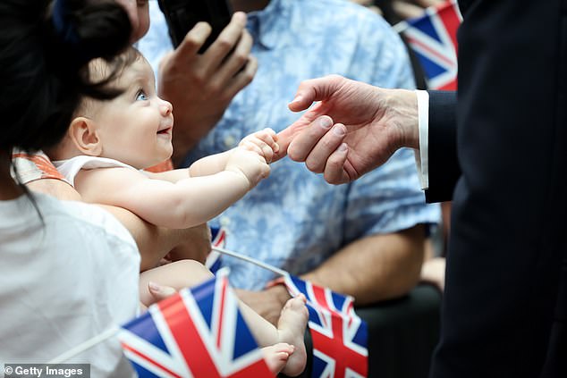 Arriving for the four-day trip, Prince William took time to greet a number of people gathered near the airport's famous Rain Vortex – including eight-month-old Albane Costa.