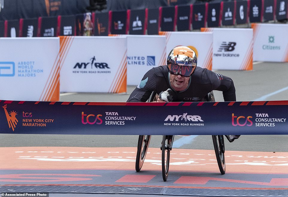 Marcel Hug from Switzerland crosses the finish line first in the men's wheelchair division of the Marathon for the sixth time