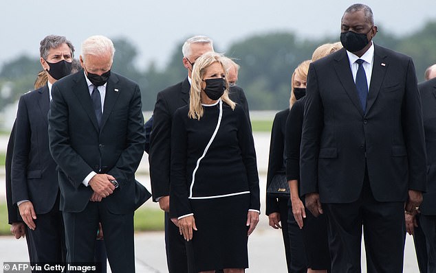 US President Joe Biden (L), US First Lady Jill Biden and US Secretary of Defense Lloyd Austin (R) attend the dignified transfer of the remains of a fallen soldier, one of the US service members who died during the war.  withdrawal from Afghanistan