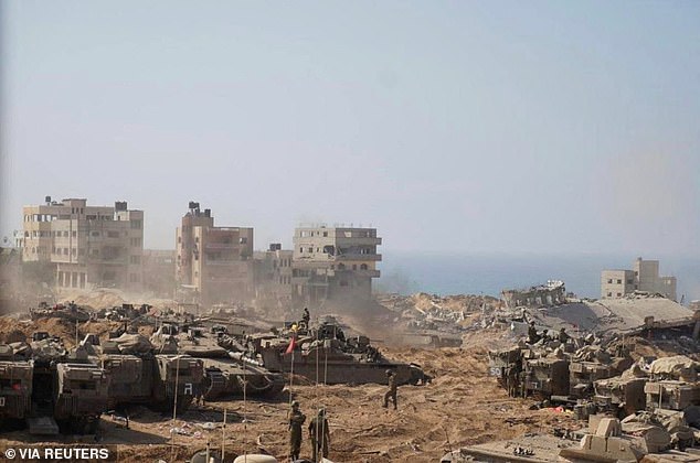 Israeli soldiers and tanks take position in the heavily bombed Gaza Strip