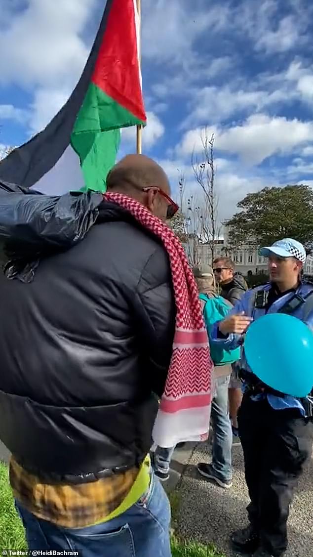 A police liaison officer was seen leading the protester away from the protest area