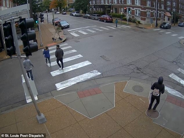 The teen (in gray, walking to the couple's left) is accused of hitting a 42-year-old woman in the head with a bottle earlier that day