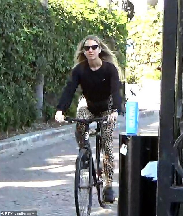 The mystery woman wore her long blonde locks and black cat-eye sunglasses with a fanny pack, as she was pictured riding her bike