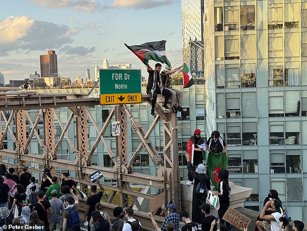 Protesters are seen here climbing the Brooklyn Bridge on Saturday as the protest across the iconic bridge continues